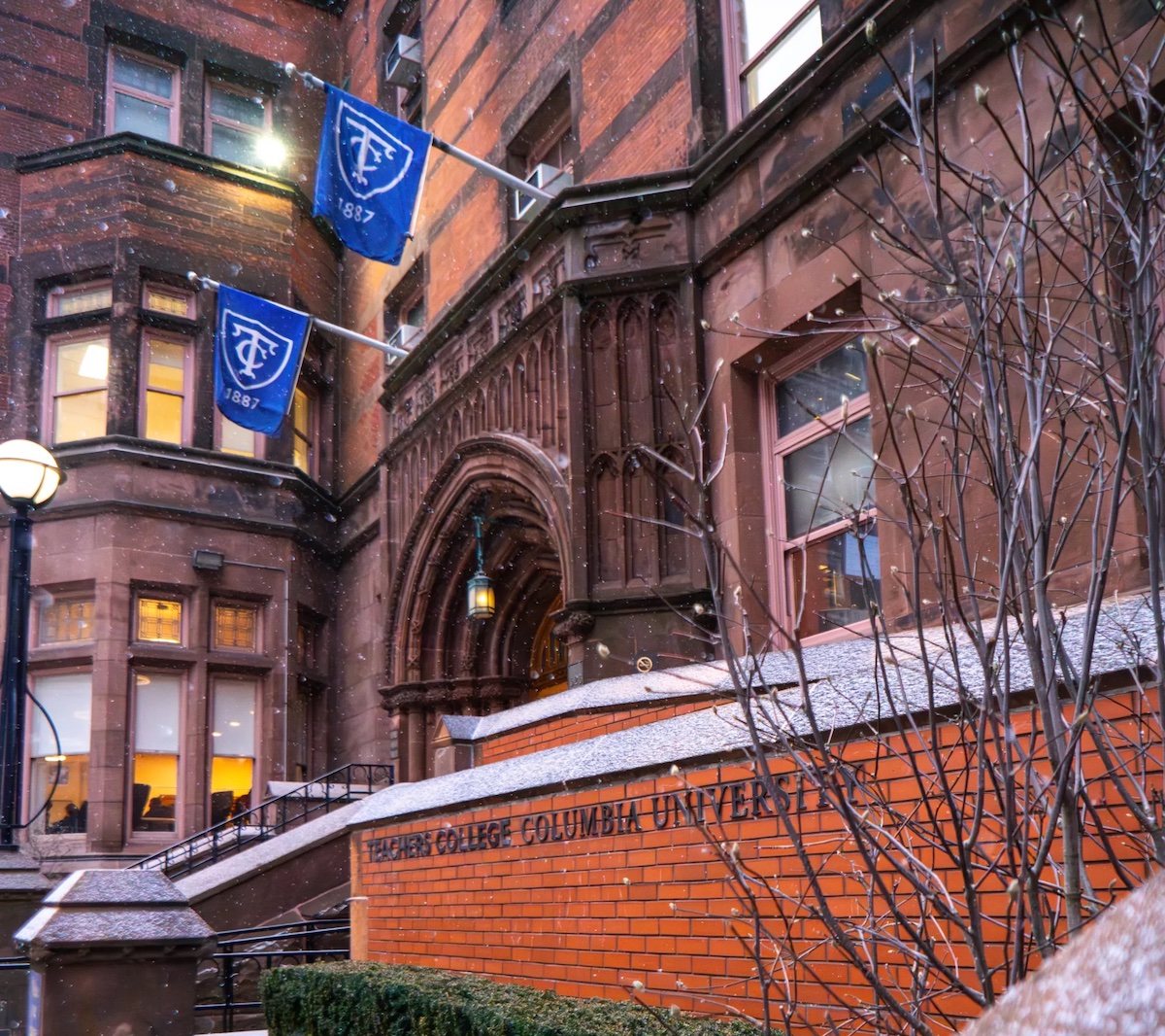The main entrance to Teachers College at dusk. Fresh snow is dusting the red brick.