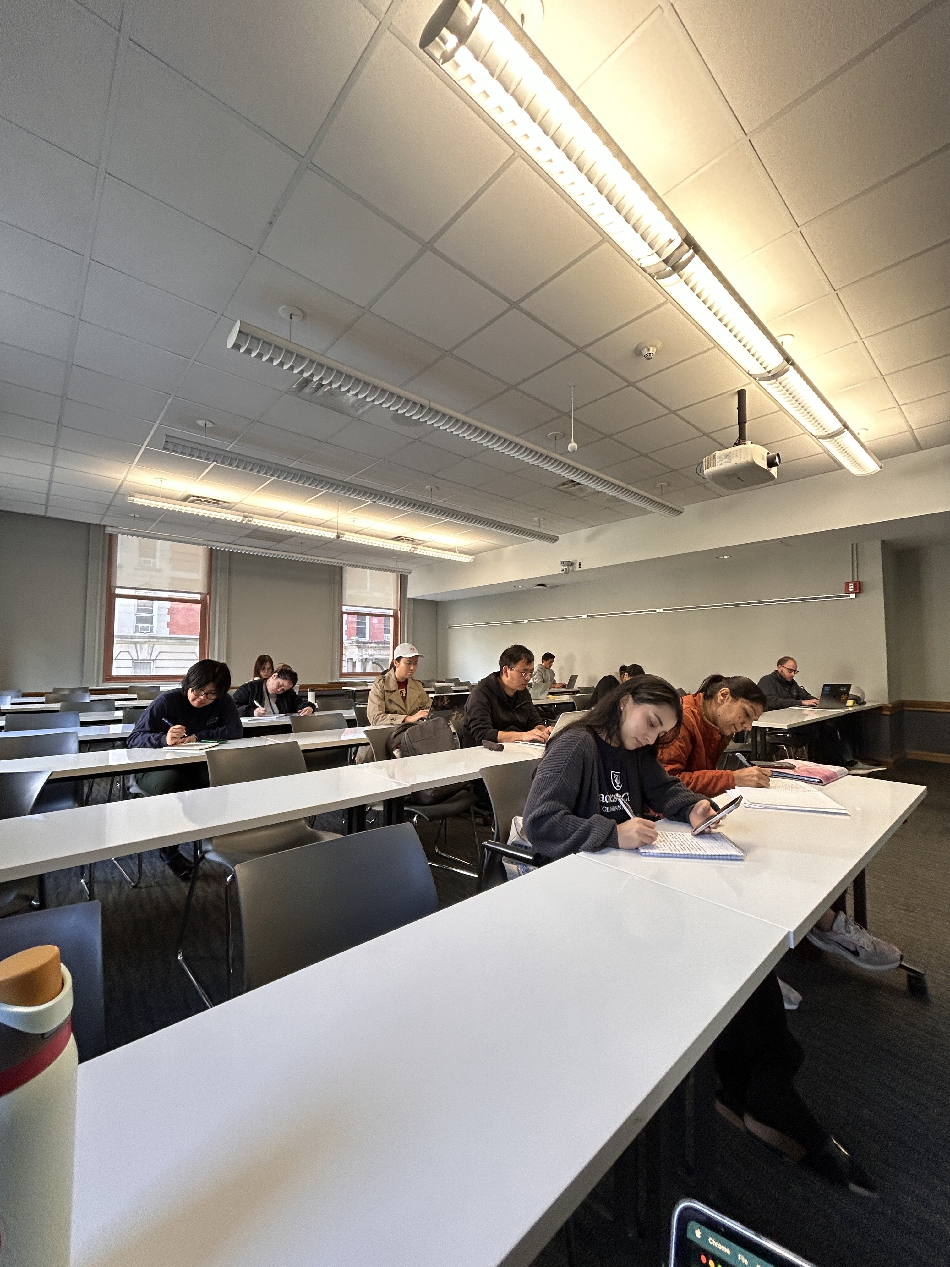 Students in a classroom writing individually in notebooks.