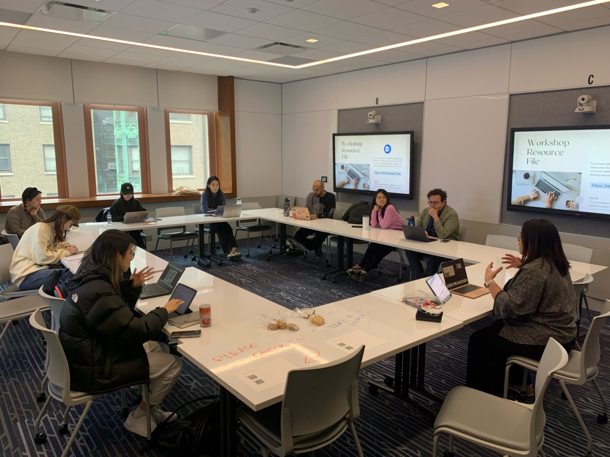 Students sitting around tables during a writing workshop