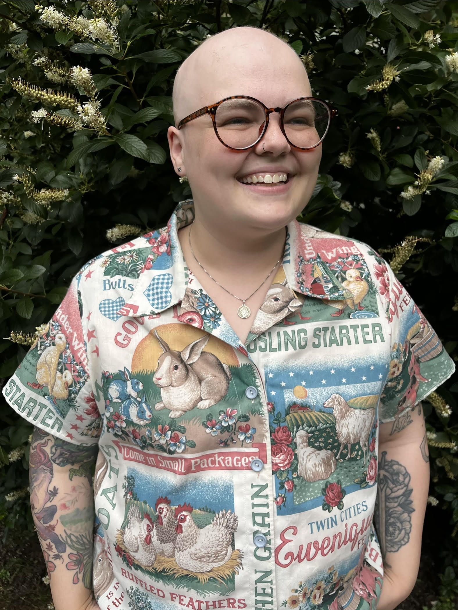 Photo of person in a colorful button up in front of a green background