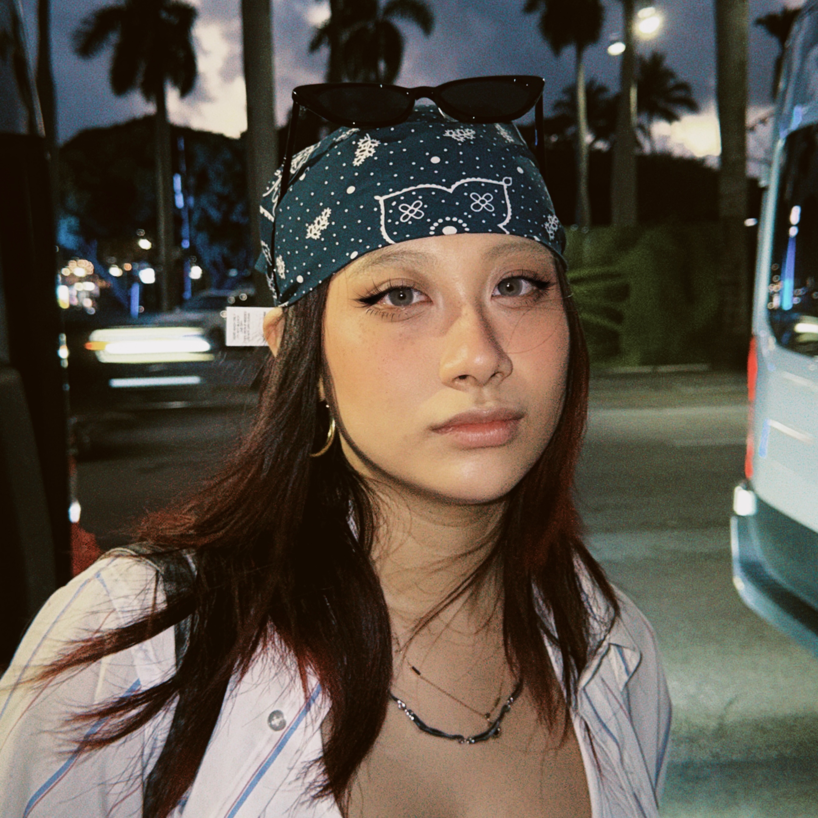 Photo of a student looking at the camera with sunglasses on top of her head