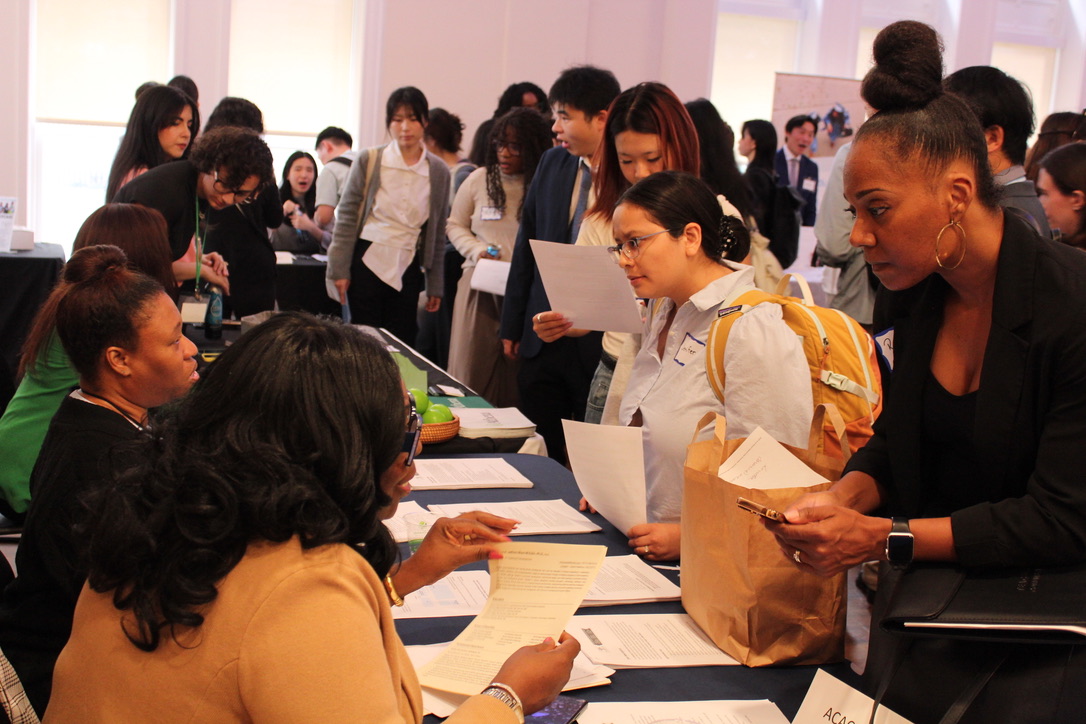 Students approaching tables with employers sitting during a career fair