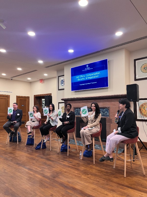 Employers on a panel holding up green check mark signs