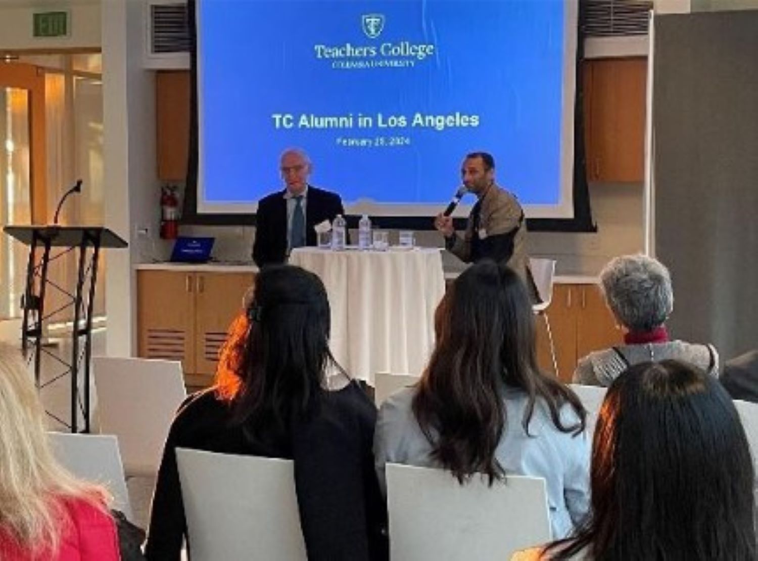 President Bailey and Vikash Reddy sitting at the front of a room speaking with alumni at the Annenberg Beach House in Santa Monica, California