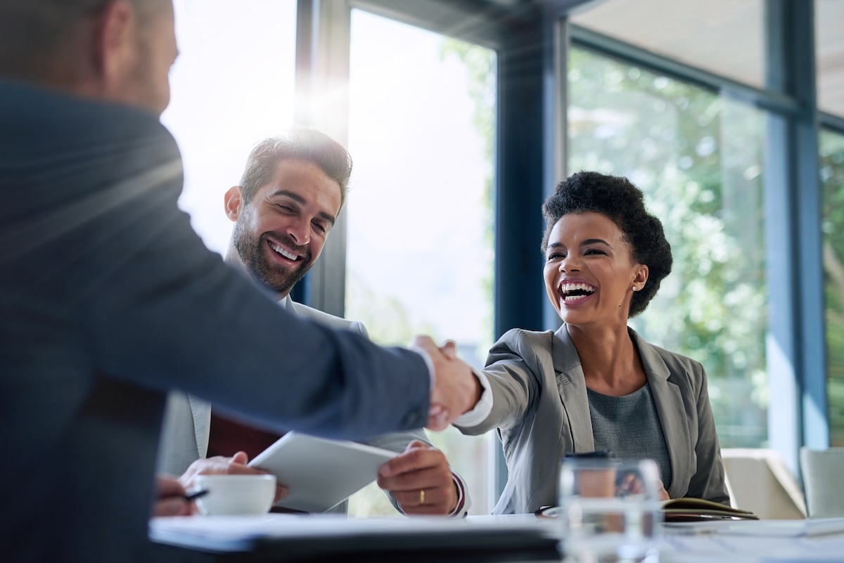 Three business professionals sit at a conference table