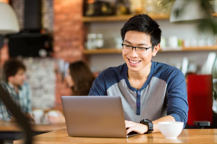 A man working on a laptop sitting in a coffee shop