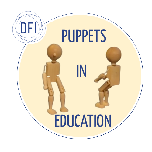Two wooden marionette puppets face each other against a pale yellow background with the text “Puppets in Education” between them. A small logo for the Digital Futures Institute is in the upper left corner.