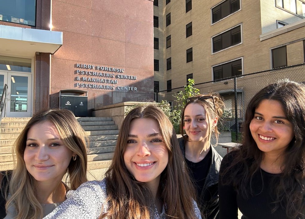 Four students standing in front of the Kirby Forensic Psychiatric Center and Manhattan Psychiatric Center