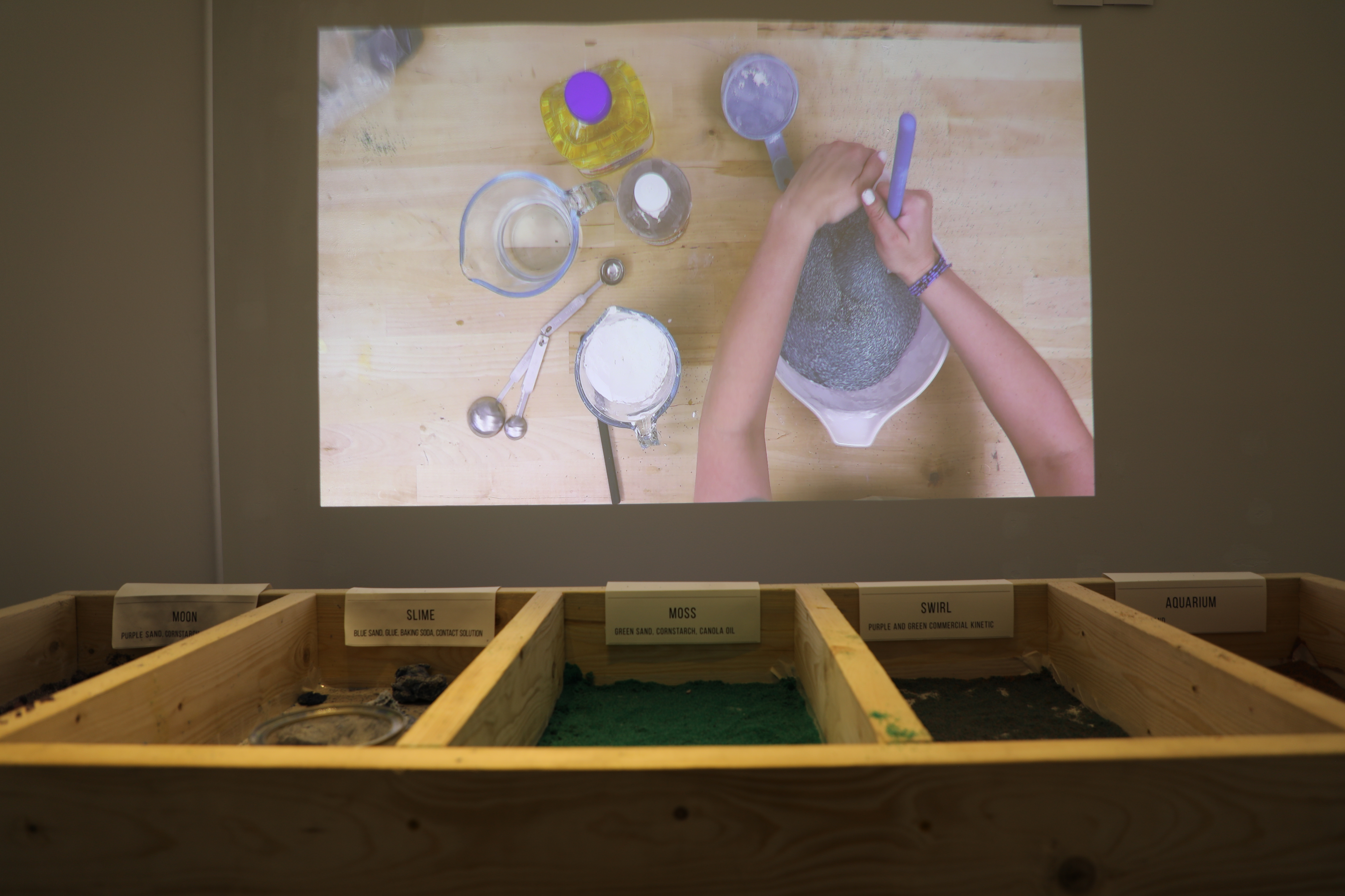 three recipes of mixed sand in wooden boxes with a film of hands mixing the sand