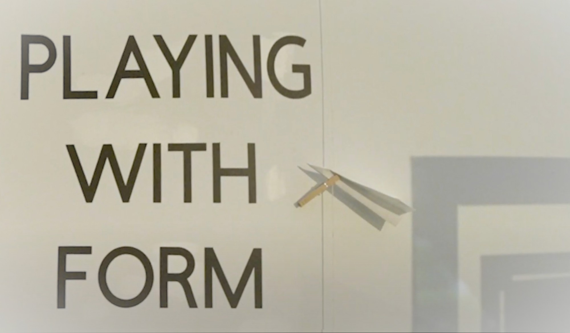 Title image of a wall with the words playing with form next to a paper airplane  and shadow of a frame