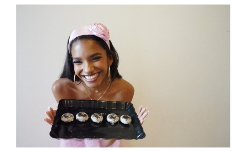Nyla holding a plate of mini donuts