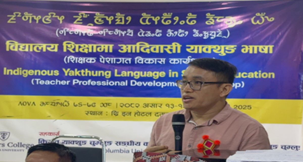 Prem Phyak standing in front of a banner with writing foreign in a language holding a microphone