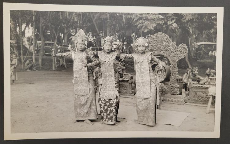 Three dancers pose for the camera. They wear traditional Balinese regalia. The photograph is in black and white.