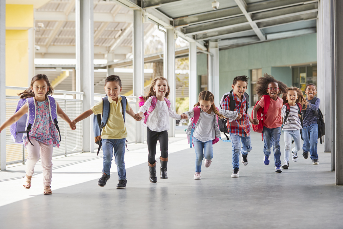 Young students run through a hallway holding hands