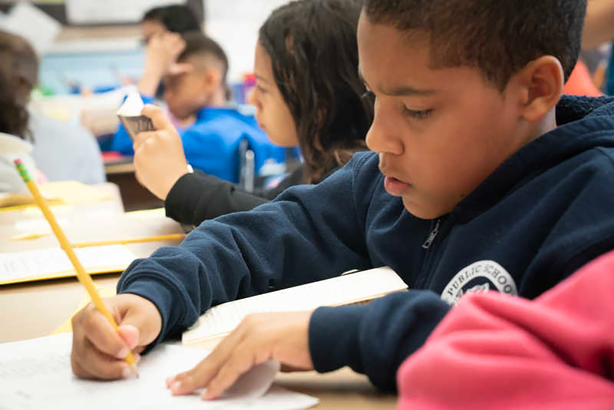 Child writing in classroom