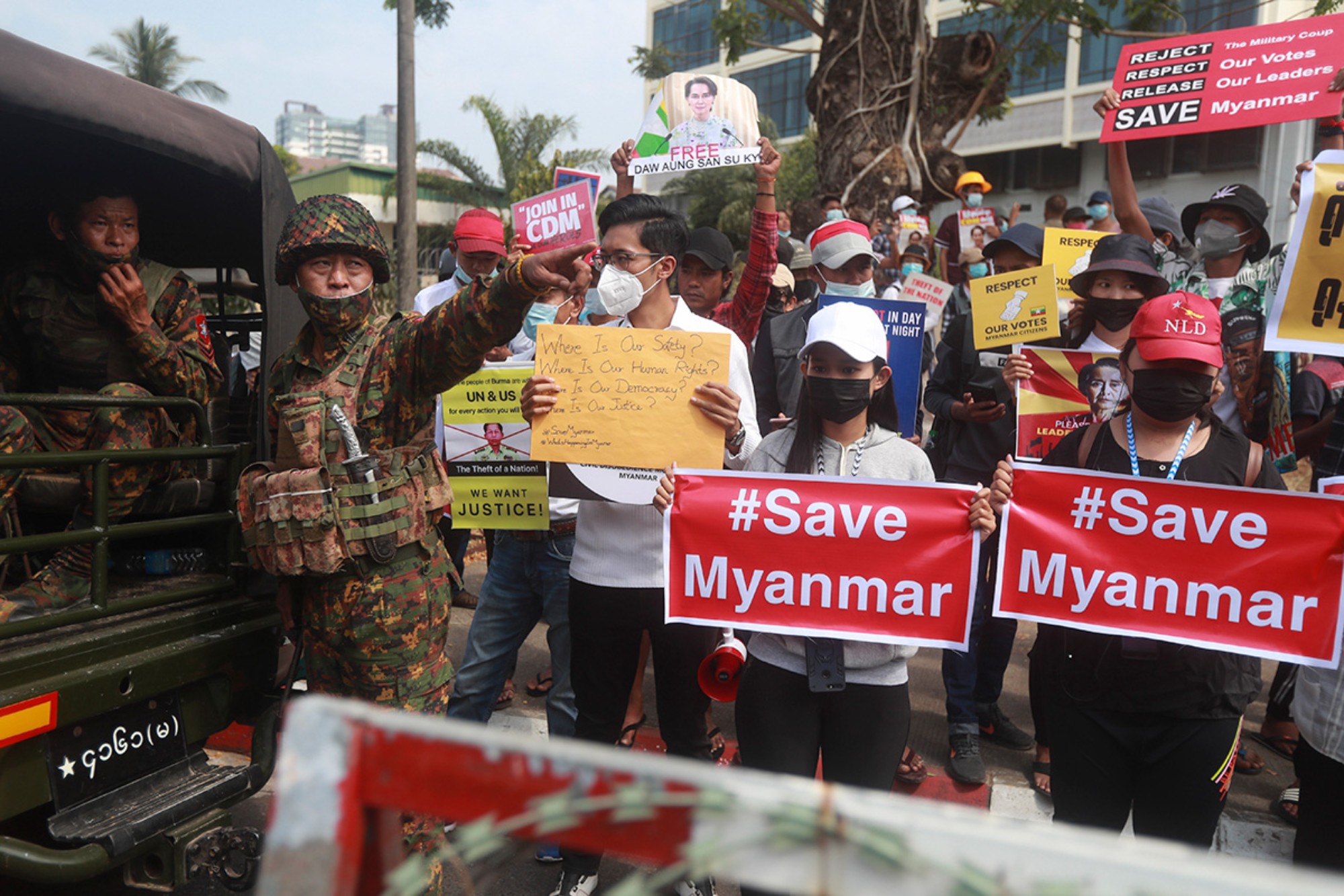 Protesters hold signs that read 