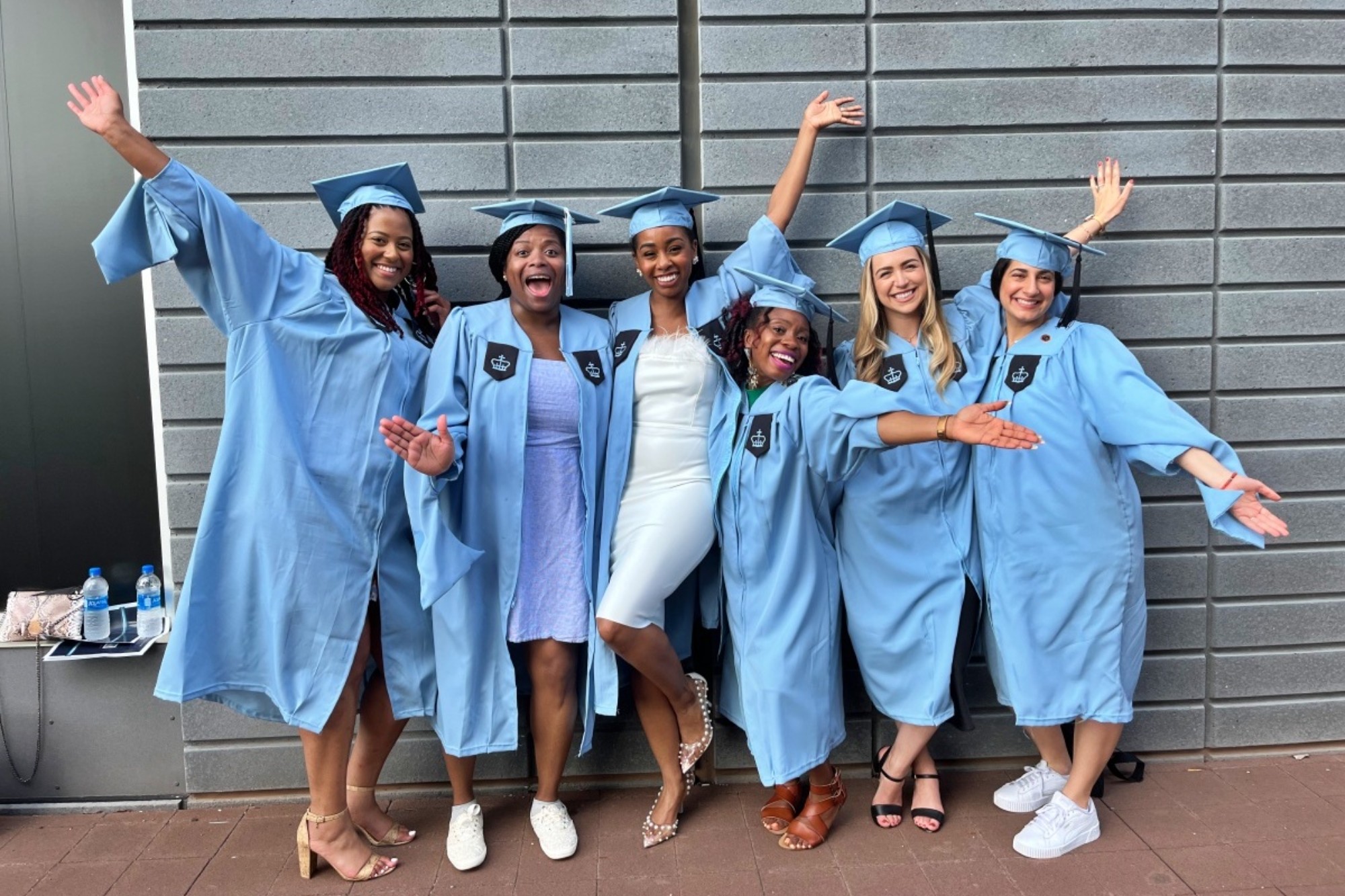 A group of graduates cheering at the camera