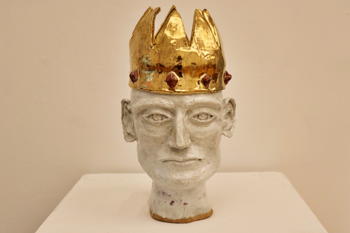 A non-binary bust, featuring a gold crown. Made of sculpting clay.