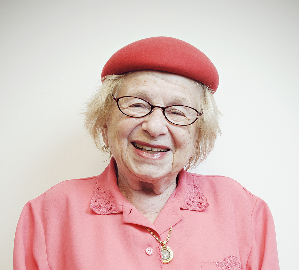 Dr Ruth smiling in a pink hat and pink shirt