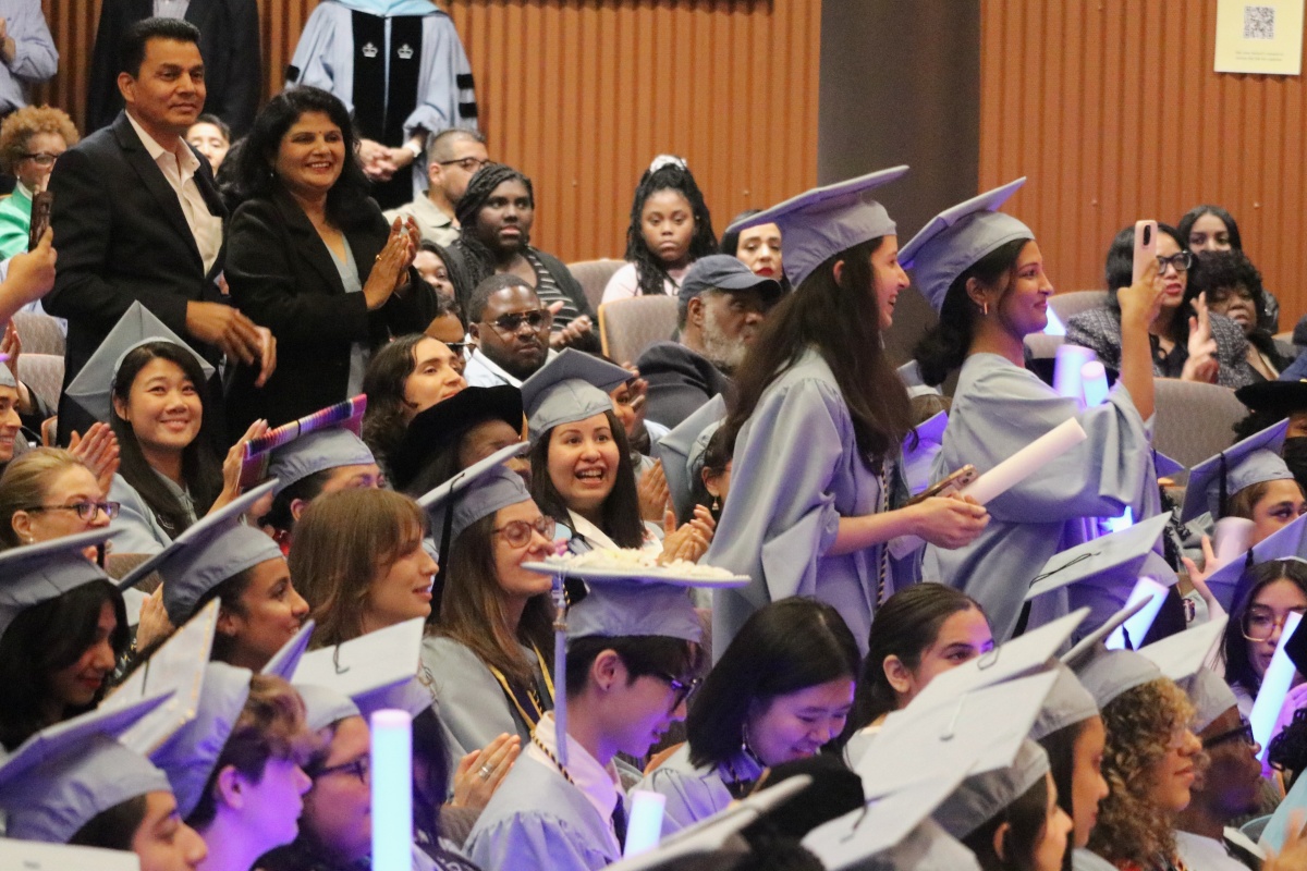 family smiles proudly at graduate