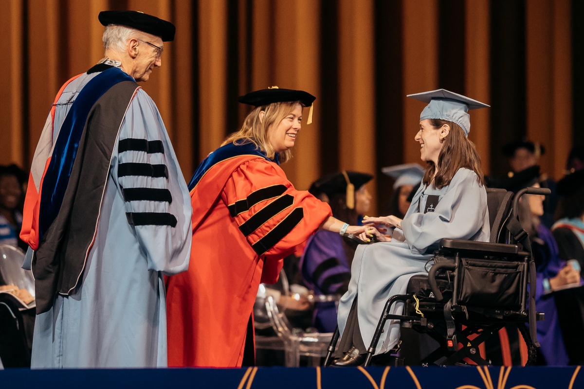 President Bailey, Provost O'Meara and a graduate who is using a wheelchair