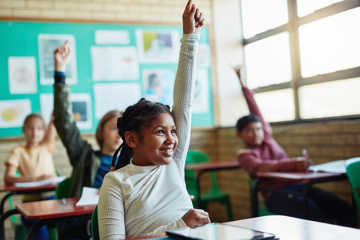 girl raises her hand in class