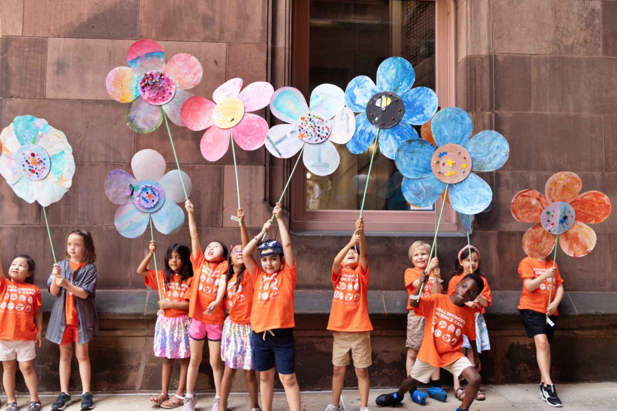 Children hold giant craft flowers as part of the Hollingworth Science Camp Parade.
