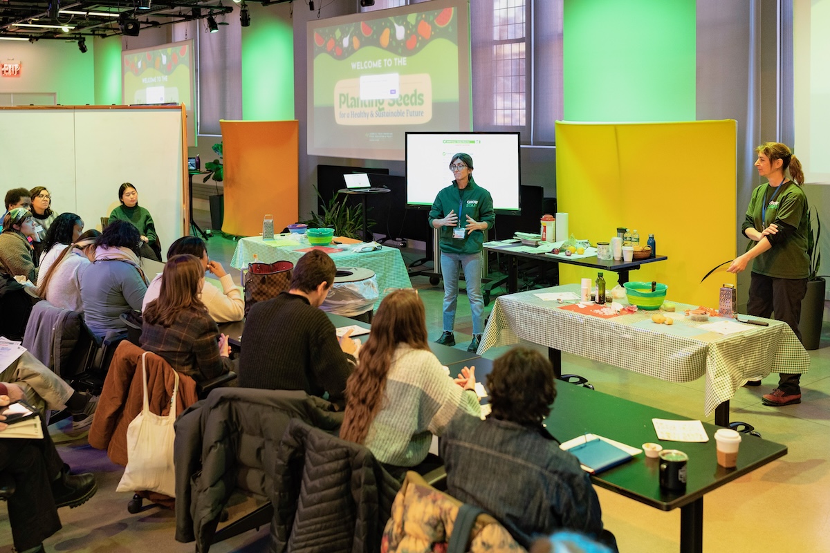 Two people address an audience at a food education conference