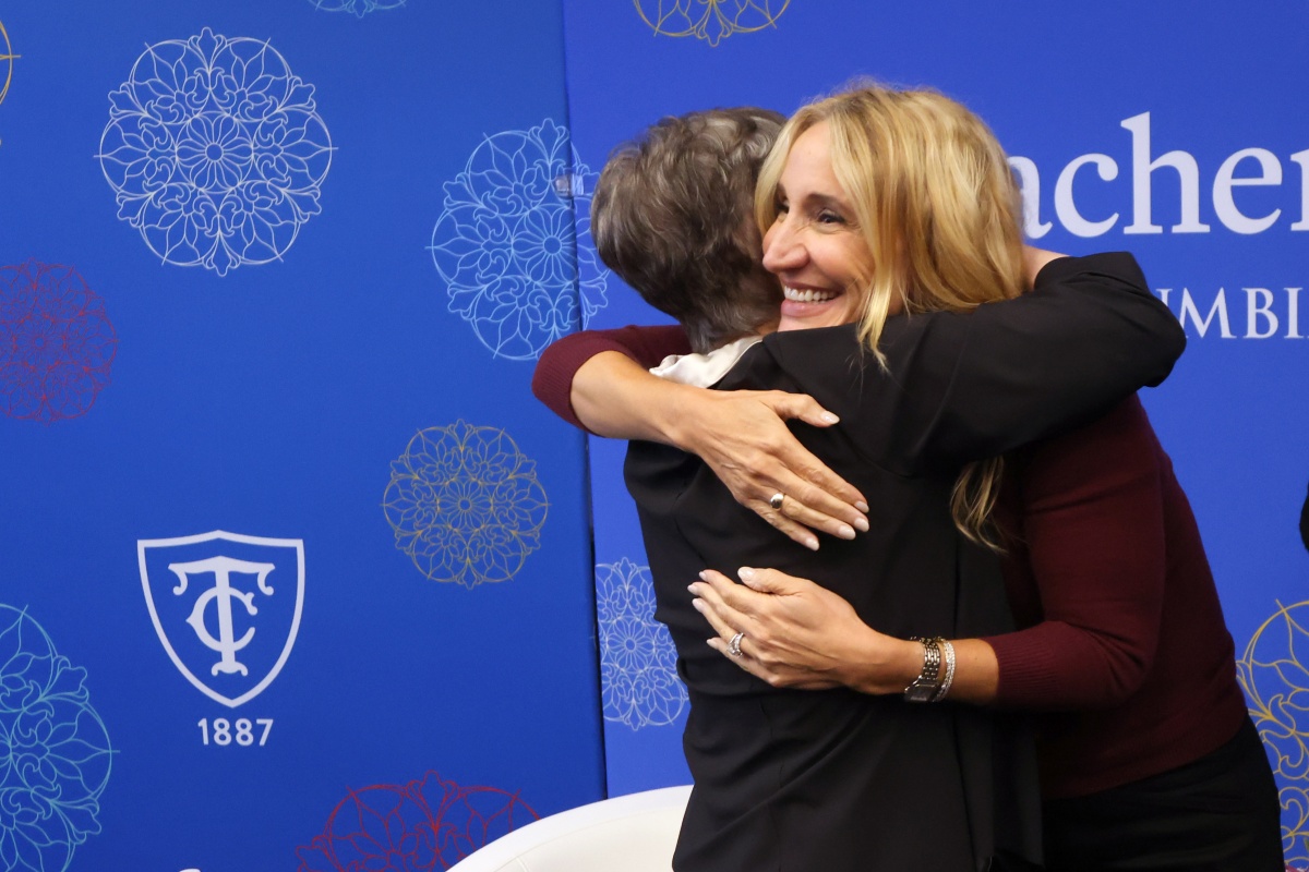 Debra Noumair and Monique Herena hug at the XMA Fireside Chat.