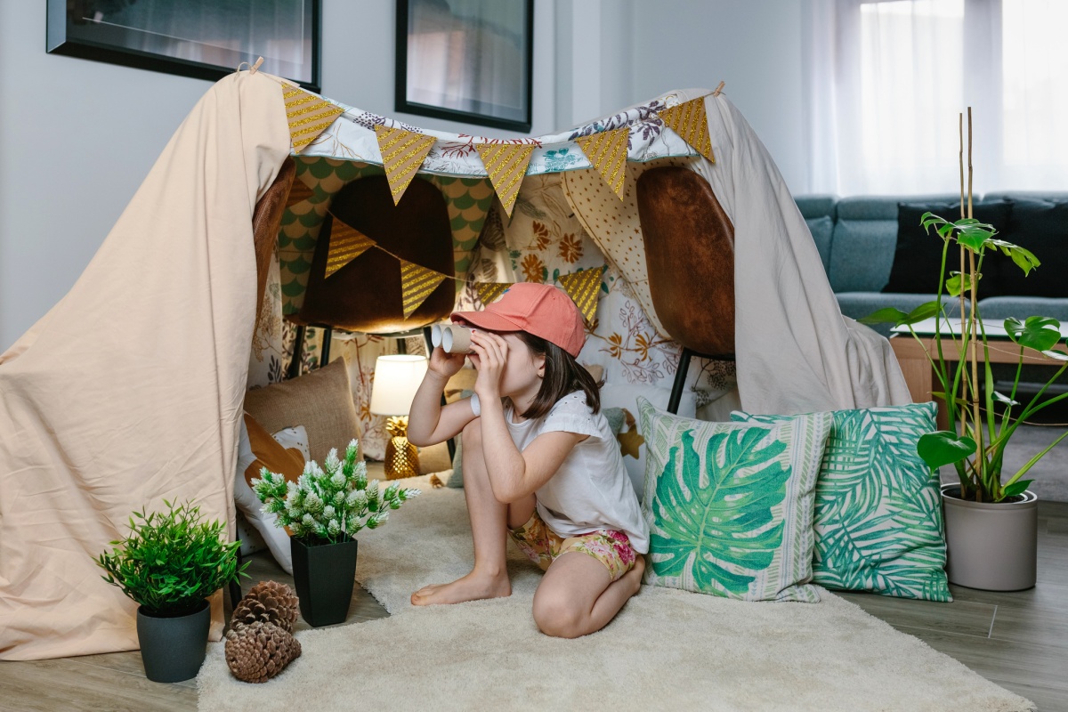 child with fort in living room