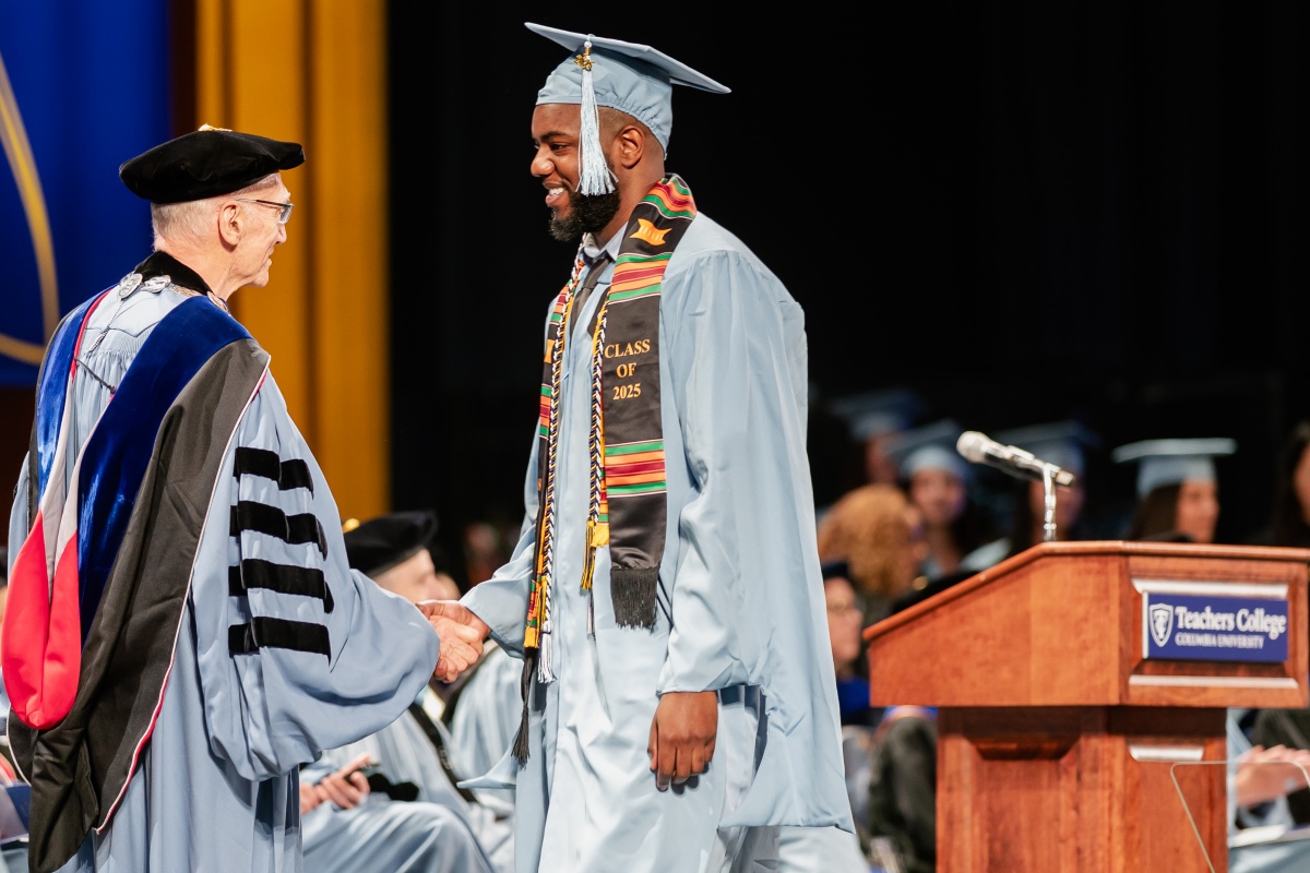 Student shakes hands with President Bailey