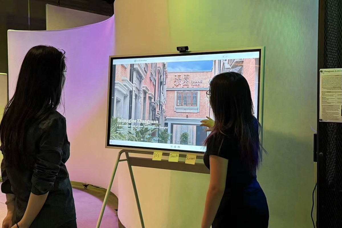 Yuyang hu standing infront of a screen presenting a project to one person