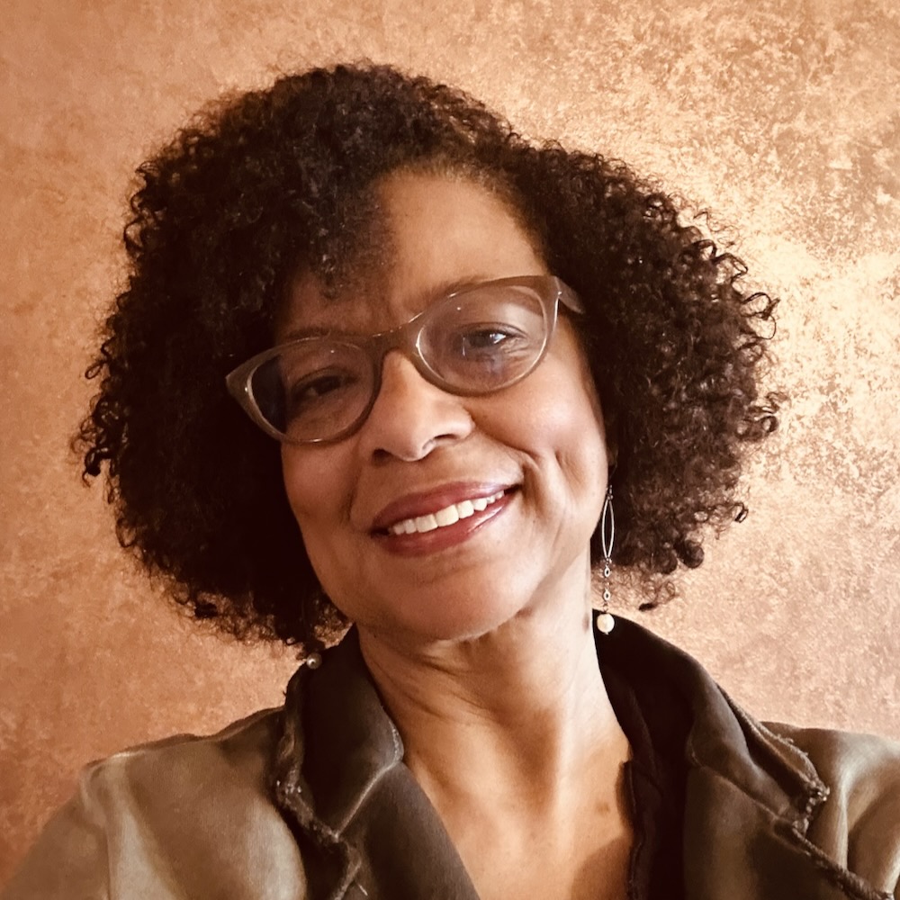 lynnette overby, a woman with dark brown hair and glasses, smiles