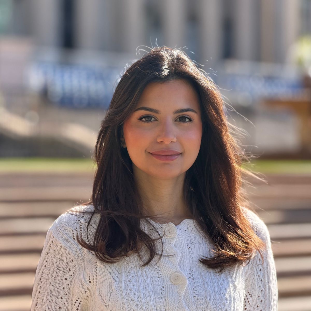 Sara Albaker smiling in front of a brick wall