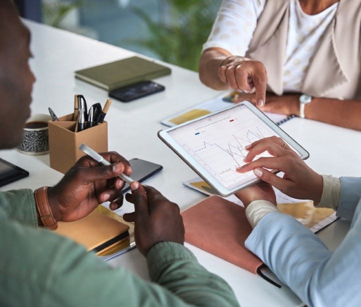 Students around a table with notebooks and tablet