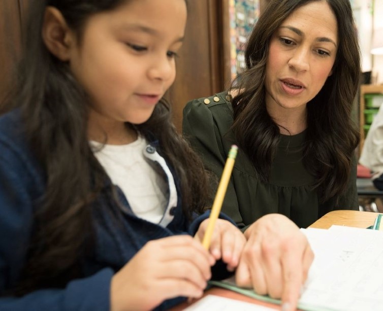 A graduate student teacher working with a young student
